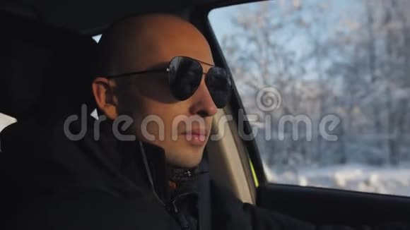 男的冬天太阳眼镜在夕阳下乘车视频的预览图