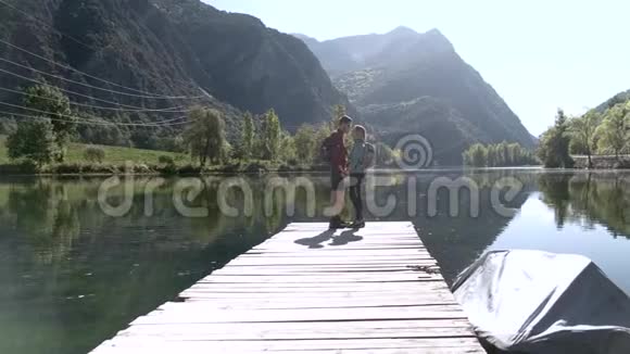 两个旅行徒步旅行者在山上的湖边接吻视频的预览图