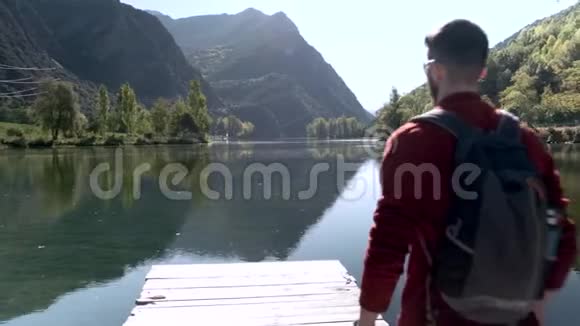 徒步旅行者带着背包来到湖边看风景视频的预览图