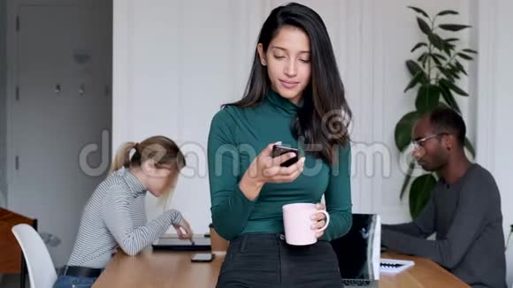 年轻的印度女企业家在办公室用手机发送信息视频的预览图