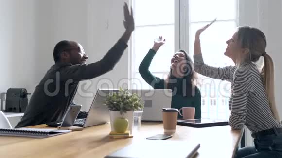 一群成功的年轻商人举起他们的右手在合作的地方视频的预览图