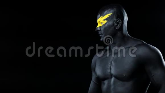 男人选择复制空间健美运动员有黄色的面部艺术和黑色的身体油漆他的彩色肖像和视频的预览图