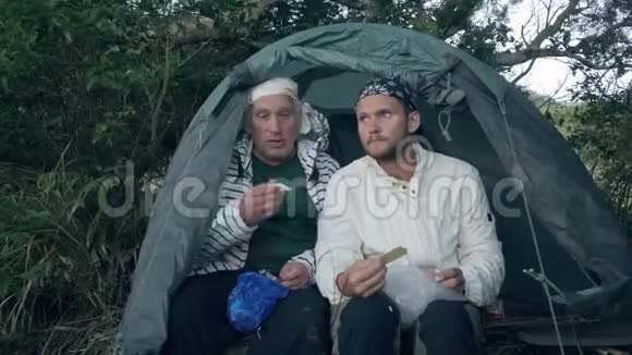 两个露营者在露营帐篷里吃零食视频的预览图