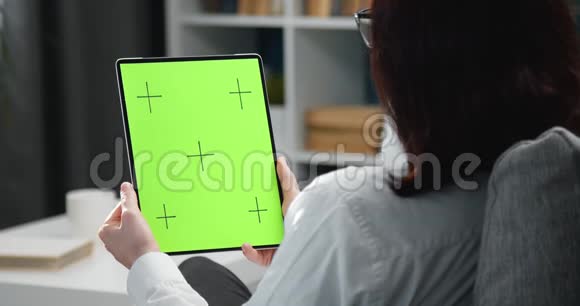 女性手持平板电脑的背面画面视频的预览图
