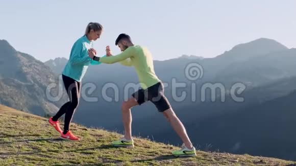 健康的年轻夫妇早上一起在山路上做伸展运动视频的预览图