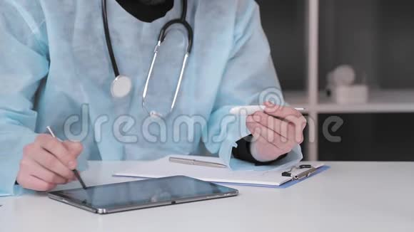 医生手里拿着一个电子温度计用手写笔在平板电脑上记录着结果视频的预览图
