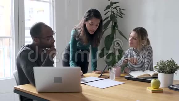 一位年轻的女企业家向同事解释了一个关于合作场所的项目视频的预览图
