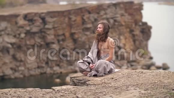 约吉坐在海边的岩石上视频的预览图