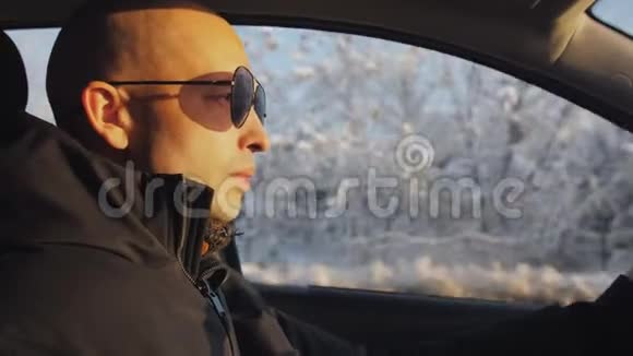 冬天戴太阳镜的人坐在车里视频的预览图
