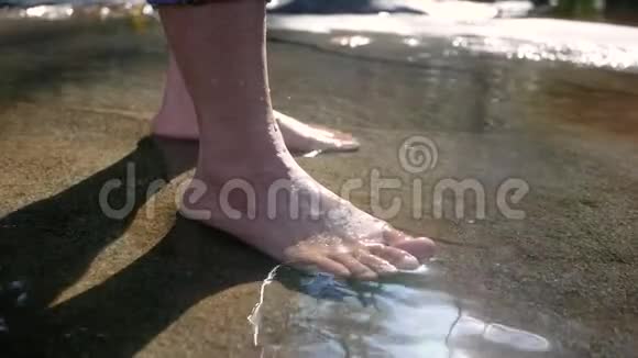 赤着脚的年轻女子在水流缓慢的溪流中溅起水花踢着腿女士们享受假期视频的预览图