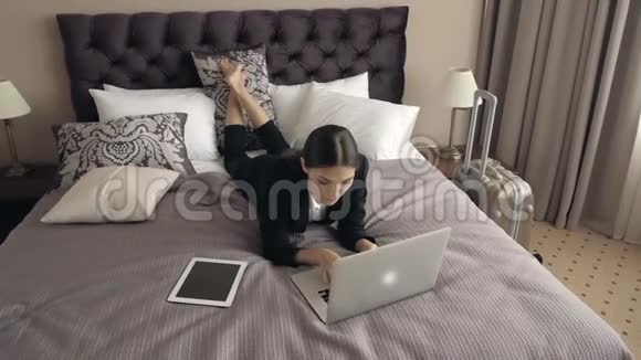 商务旅行概念幸福的商务女性电脑躺在酒店床上在现代设备室工作视频的预览图