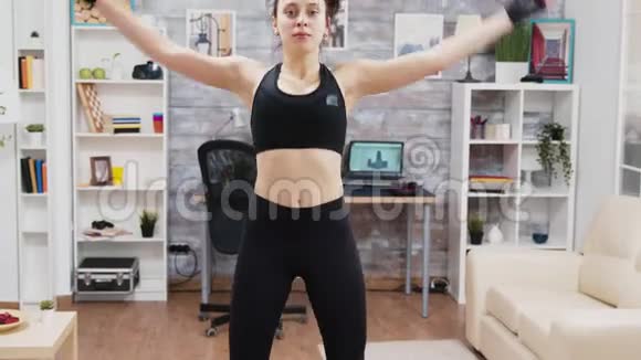 年轻女子在家做跳跃运动视频的预览图