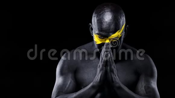 男子体育迷和健美运动员与黄色的脸艺术和黑色的身体油漆他的彩色画像视频的预览图