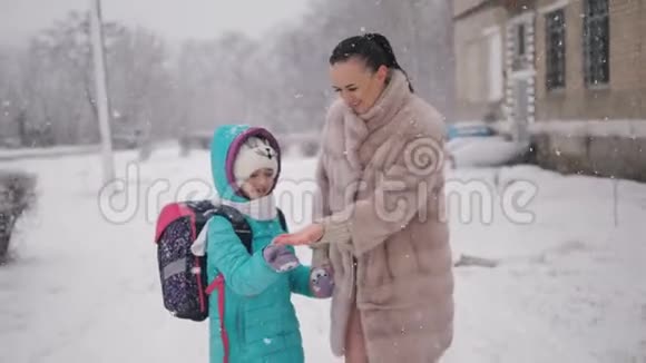 妈妈和女儿在冬天放学回家视频的预览图