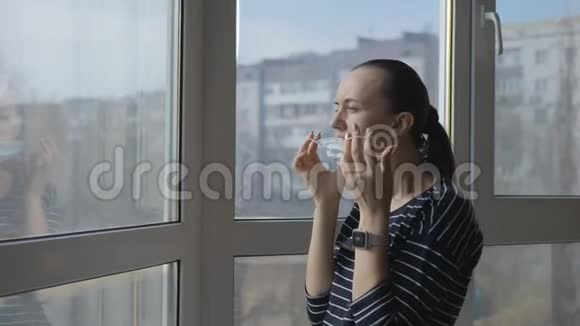 一个女人脸上戴着防护面罩打开窗户视频的预览图