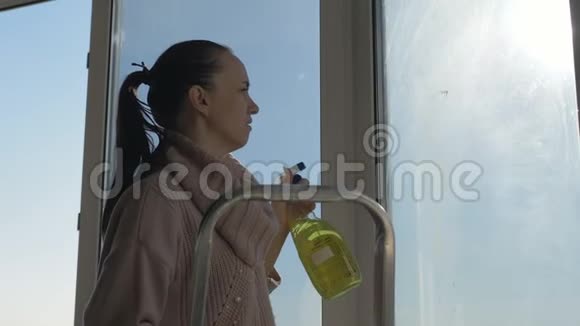 一位女管家正在洗公寓里的窗户把洗涤剂喷洒在肮脏的表面上然后擦拭视频的预览图