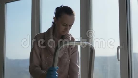 女人站在梯子上洗公寓里的全景窗户视频的预览图
