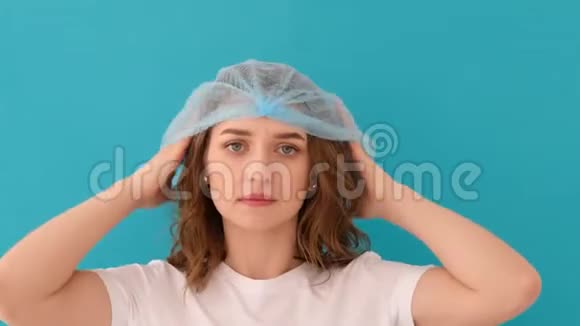 冷静的年轻女子戴着蓝色的医用帽子视频的预览图