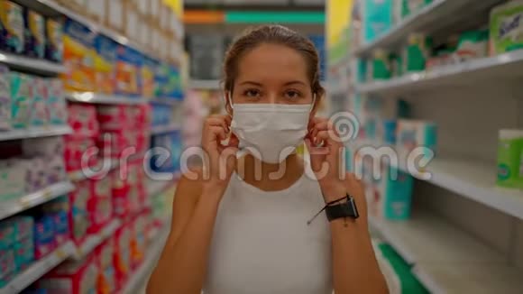 年轻女子戴着防护面罩站在商店里看着摄像机微笑视频的预览图