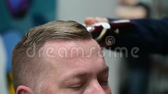 男人理发店理发一位剪头发金发的男士的贴身剪裁视频的预览图