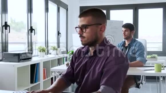 软件开发人员与计算机在现代创业办公室工作视频的预览图