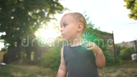 一个两岁的白发男孩站在操场上思考着什么视频的预览图