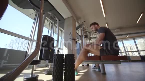 在健身房使用坐排机的年轻人视频的预览图