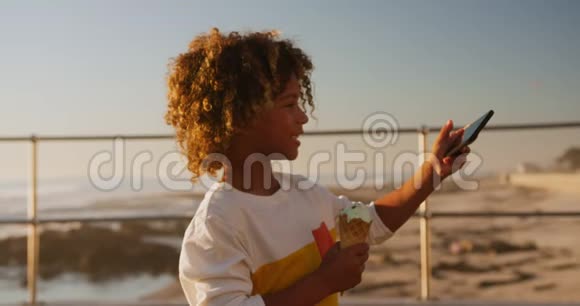 带着冰淇淋的小男孩用电话视频的预览图