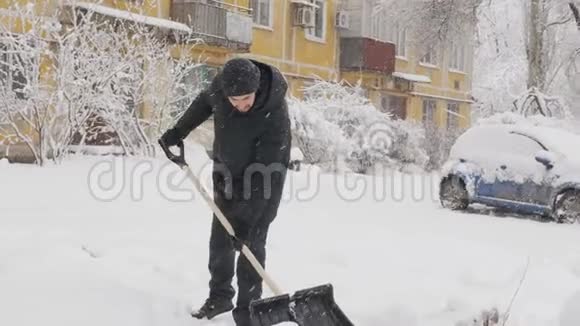 一个人在院子里用一把大铲子清理雪视频的预览图