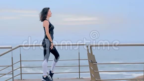 在海滨积极健身的女人做伸展运动视频的预览图