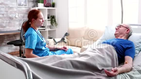 女看守和躺在床上的老人谈话视频的预览图