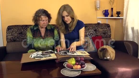 奶奶和孙女一起看黑白旧相册视频的预览图