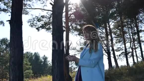 美丽的年轻女子把针叶树的锥子扔在森林里视频的预览图