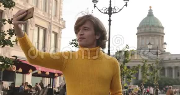 帅哥自拍从外面看他穿着黄色的毛衣黑色的雨衣或夹克是他的手视频的预览图