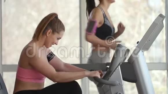 年轻女子在现代健身房里使用跑步机视频的预览图