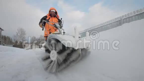 冬天男人用清扫车清扫院子里的积雪视频的预览图