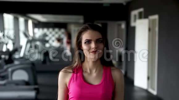 年轻漂亮女人训练的肖像哑铃坐在健身房的长凳上健康的生活方式运动观念视频的预览图