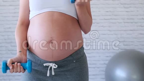 孕妇在家用哑铃做运动视频的预览图
