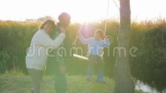 儿童与成人的相互关系在阳光明媚的芦苇丛中欢乐的人在河边休闲视频的预览图