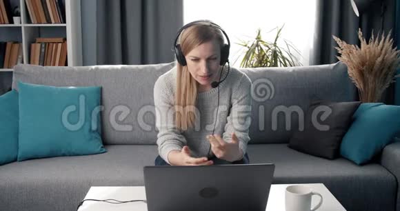 戴耳机的成熟女人在笔记本电脑上开视频会议视频的预览图