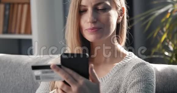 使用信用卡和智能手机购物的成熟女性视频的预览图