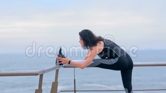 穿着运动服的女人在海边做运动视频的预览图