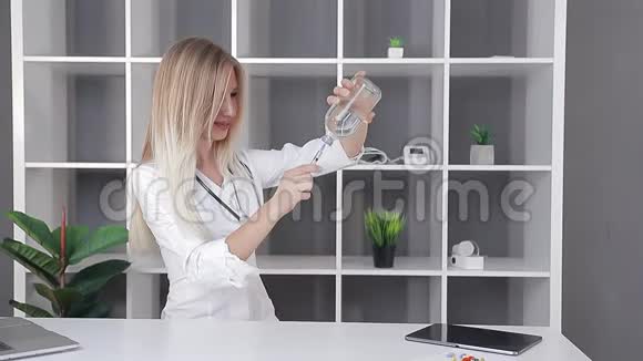护士医生从一个工作的医疗办公室的一个大罐子里把药拨进注射器里视频的预览图
