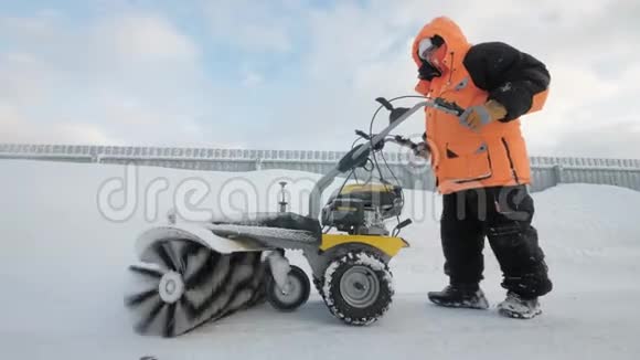 冬天男人用清扫车清扫院子里的积雪视频的预览图