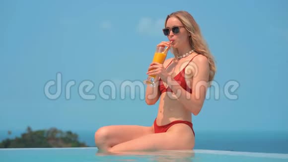 美丽的金发美女穿着红色泳衣度假休息视频的预览图
