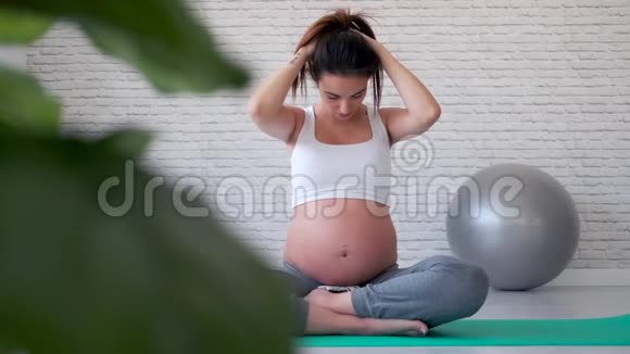 漂亮的年轻孕妇在分娩前教室做普拉提运动后伸展身体视频的预览图