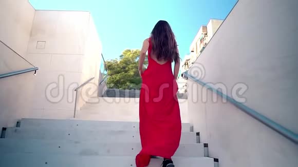 美丽的女人穿着红色优雅的裙子城市白人背景视频的预览图