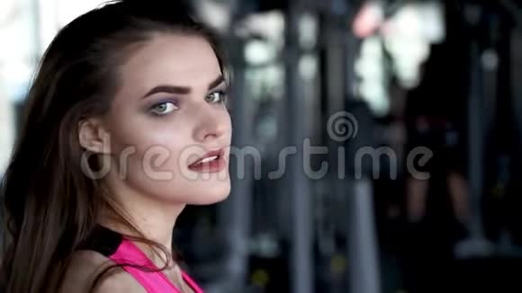 年轻漂亮女人训练的肖像哑铃坐在健身房的长凳上健康的生活方式运动观念视频的预览图