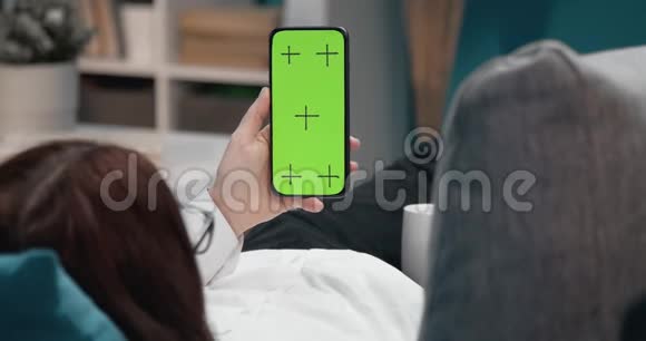 年轻女子拿着手机看着色度键屏视频的预览图