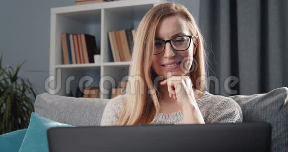 成熟的女士在家里用笔记本电脑聊天视频的预览图